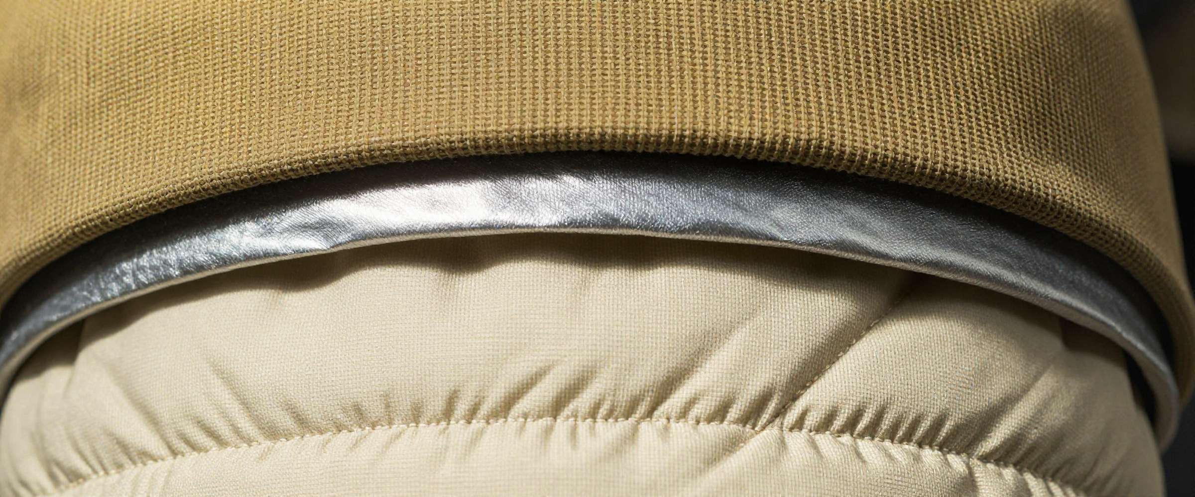 Macro view of turnout gear construction: woven outer shell, moisture barrier film and quilted thermal liner.